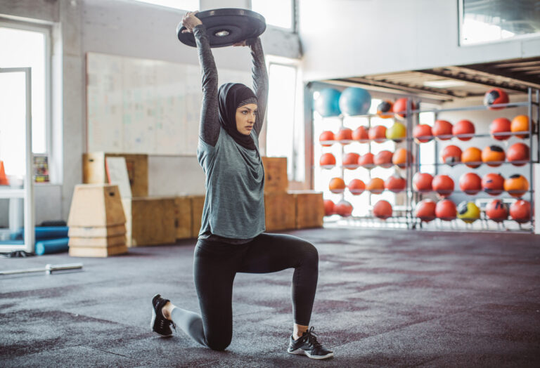 Young woman on cross training exercising. Wearing sports clothing and hijab.